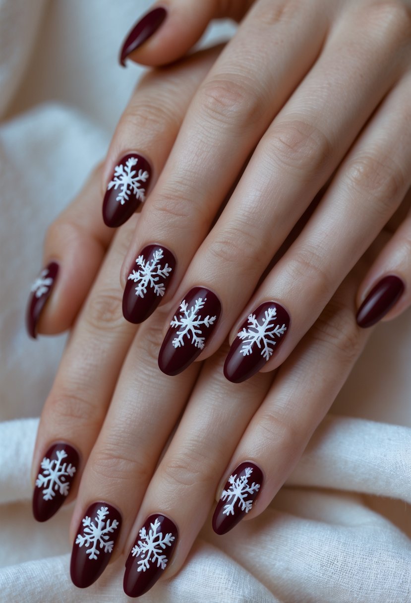 Close-up of hands with burgundy nails decorated with white snowflake designs.